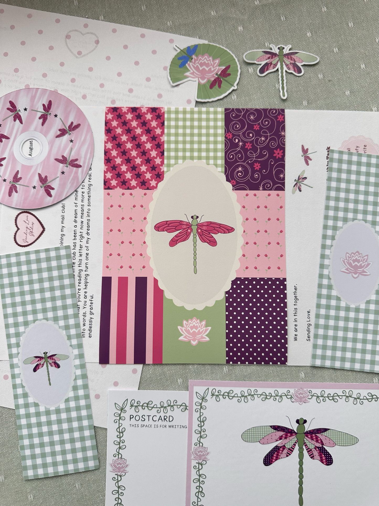 Collection of stationery items with dragonfly designs on a textured surface