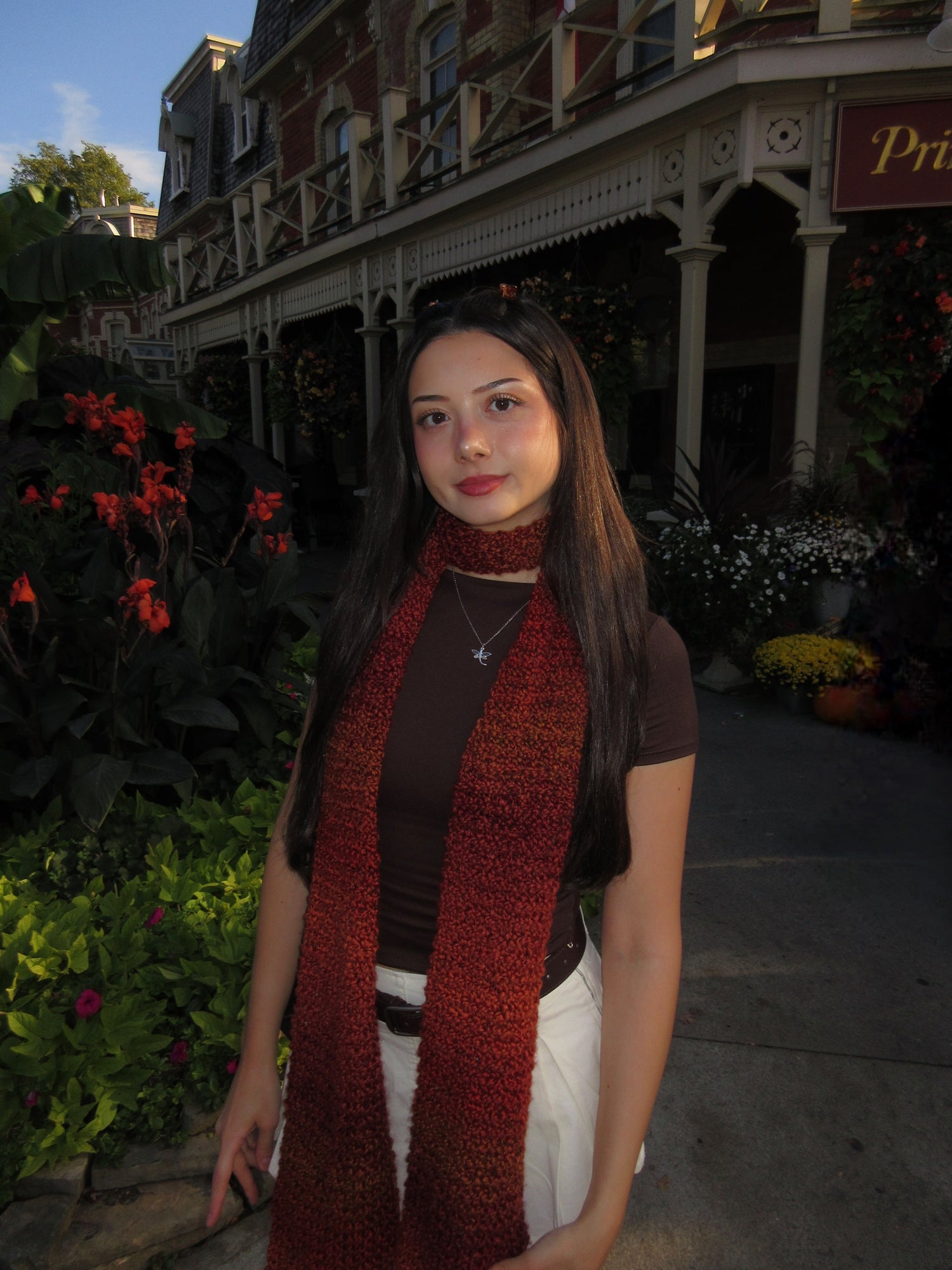 Woman wearing a red scarf in front of a building with decorative architecture
